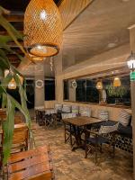 een restaurant met houten tafels en stoelen en een kroonluchter bij Hotel el Ancla Campestre in Villeta