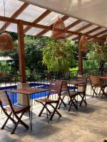 een terras met tafels en stoelen onder een pergola bij Hotel el Ancla Campestre in Villeta