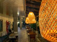 een groot hanglicht in een restaurant met tafels en stoelen bij Hotel el Ancla Campestre in Villeta