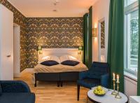 Un dormitorio con una cama y dos sillas. en SPiS Hotell Amber, en Luleå
