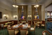 Un restaurante con mesas, sillas y ventanas. en Boutique Hotel Seven Days, en Praga