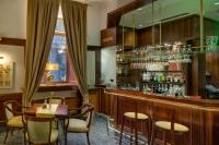 Un restaurante con un bar con sillas y una mesa. en Boutique Hotel Seven Days, en Praga