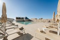 una fila de tumbonas y sombrillas junto a una piscina en Hotel Reveron Plaza, en Los Cristianos