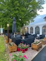 eine Terrasse mit Stühlen, Blumen und einem Sonnenschirm in der Unterkunft Le Clos Joli in Haybes