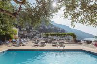 a pool with lounge chairs and a view of the mountains at Hotel Poseidon in Positano