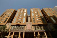 a tall building with two tall buildings at Abraj Al Tayseer Tuwa Hotel in Makkah