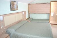 Łóżko lub łóżka w pokoju w obiekcie Hotel Arlecchino