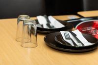 ゴスフォードにあるGosford Inn Motelのグラス2枚と皿とフォークナイフ