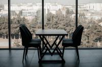 纳曼干Imran Palace Hotel的窗前的一张桌子和两把椅子