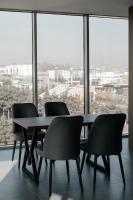 纳曼干Imran Palace Hotel的有大窗户的房间里有一张桌子和几把椅子