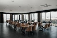 纳曼干Imran Palace Hotel的餐厅里有桌椅和窗户。