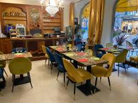 a restaurant with tables and chairs and a chandelier at Balzac Hôtel Restaurant in Fougères