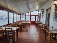 Boissise-le-Roiにあるle pressoirの木製のテーブルと椅子と窓のあるレストラン