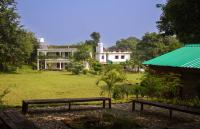 GhamrurPong Retreat的一座公园,在一座建筑前有两把长椅