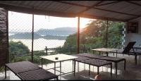 GhamrurPong Retreat的阳台设有桌子,享有海景。
