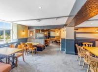 a restaurant with tables and chairs and a fireplace at The Ladybower Inn in Bamford