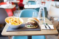 un panino e una ciotola di patatine fritte su un tavolo di TIP HOTEL CAMBRAI ex HOTEL F1 a Cambrai