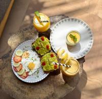 a table with two plates of food and a drink at The Nest Tropical Oasis Resort in Paje