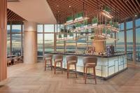 a restaurant with a bar with chairs and windows at Lanson Place Mall of Asia Manila in Manila