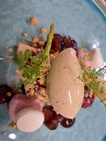 un plato con un postre con uvas y una pera en él en La Ferme du Hélivy, en Jalhay