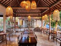 a restaurant with tables and chairs and chandeliers at Sabana Bliss in Ubud
