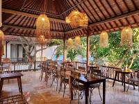 a restaurant with tables and chairs and chandeliers at Sabana Bliss in Ubud