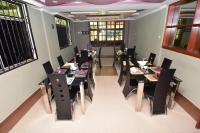 een eetkamer met zwarte tafels en stoelen bij Acres Hotels in Arusha