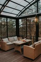 einen Wintergarten mit einem Tisch und Stühlen auf einer Terrasse in der Unterkunft Dream Park in Gyulagarak