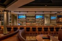 un bar con mesas, sillas y TV en Munich Marriott Hotel, en Múnich