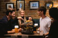 Un grupo de personas sentadas alrededor de una mesa comiendo comida en Munich Marriott Hotel, en Múnich