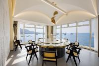 山海行旅三梦季汤池海景酒店 في Houjiazhuang: غرفة طعام مطلة على الماء