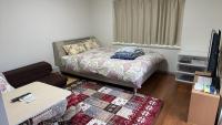 鹿児島市にある短期賃貸ビッグバーンズマンション田上のベッドとソファのある小さな部屋