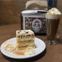 Anavada Inn & Suites - Prince George في برينس جورج: قطعة كيك على صحن بجانب مشروب