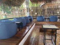 Un restaurante con sofás y mesas azules sobre un suelo de madera. en Dive Camp, en Dauin