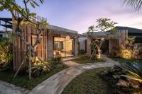 a home with a walkway through a yard with trees at Widji Garden Villa in Uluwatu