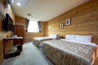 a hotel room with two beds and a television at Songyuan B&amp;B in Lugu Lake