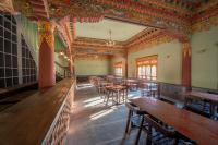 una stanza vuota con tavoli e sedie in un edificio di Taktsangri-La a Drugyel Dzong