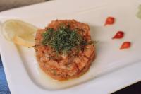 Un plato blanco con un trozo de carne con eneldo encima. en Auberge de la Source, en Chazey-Bons