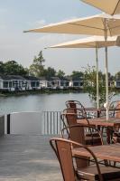 een heleboel stoelen en tafels met parasols op een terras bij Pan Ville Resort in Pathum Thani