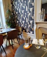 a dining room with a table and a fireplace at La maison de famille Limoges in Limoges