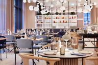 um restaurante com mesas, cadeiras e lustres em Novotel Hamburg Central Station em Hamburgo