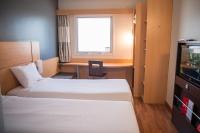 a room with two beds and a desk and a television at ibis Itu Plaza Shopping in Itu