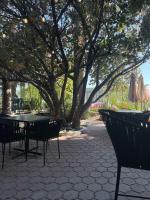 eine Terrasse mit Tischen und Stühlen unter einem Baum in der Unterkunft Hotel Villa Montes in Ezequiel Montes