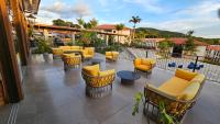 a patio with yellow chairs and tables on a balcony at Resort QSB - Um novo padrão de conforto e lazer no coração da cidade in Pirenópolis