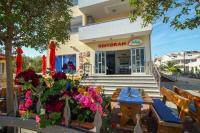 een restaurant met tafels en bloemen voor de deur bij Apartments Ars Vivendi in Trogir