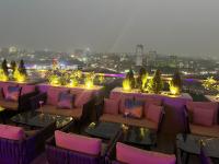 a rooftop bar with chairs and tables and lights at Luxury One-Bedroom Apt at The Signature Near Airport in Accra