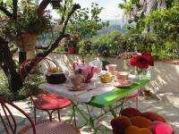 einen Tisch mit Stühlen, Tassen und Blumen darauf in der Unterkunft Les Grimaldines - Maison d&#39;Hôtes in Cagnes-sur-Mer