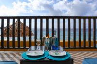 una mesa con platos y copas de vino en el balcón en Beach front luxury living - 2 bedroom condo with sea view, en Jan Thiel
