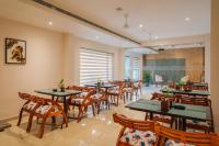 Airport Haven في إرناكولام: مطعم بطاولات وكراسي خشبية ونافذة