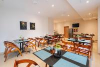 Airport Haven في إرناكولام: غرفة طعام بها طاولات وكراسي خشبية